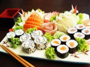 A vibrant sushi platter featuring assorted rolls, sashimi, and garnishes