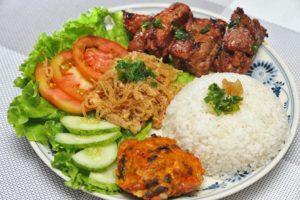 A plate featuring grilled chicken, rice, sautéed vegetables