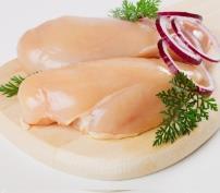 Raw chicken breasts on a wooden cutting board