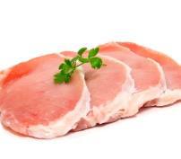 Raw pork chops garnished with a sprig of parsley