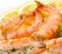 Grilled shrimp garnished with lemon slices and herbs