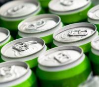 Close-up of neatly arranged green beverage cans with pull tabs,